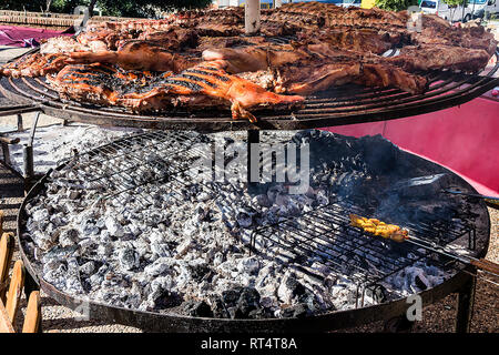 Assortment of grilled sausages and kebabs on big round grill in medieval fair Stock Photo