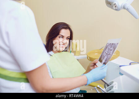 Dentist and patient are looking at x-ray. Stock Photo