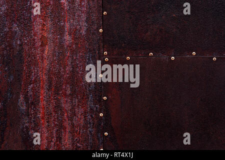 Close up dark burgundy texture color metal background with small rivets, sheet of rusty iron grunge backdrop, metallic surface, design with copyspace Stock Photo