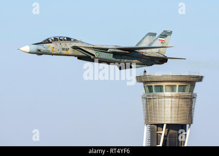 An F-14A Tomcat of the Islamic Republic of Iran Air Force, flys by an air traffic control tower. Stock Photo