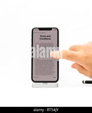 PARIS, FRANCE - NOV 5, 2017: New Apple iPhone X 10 smartphone isolated white background male hand scrolling to read Terms and conditions  Stock Photo