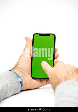 PARIS, FRANCE - NOV 5, 2017: New Apple iPhone X 10 smartphone with green chroma key backdrop against white background in male hand Stock Photo