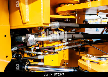 Pipes and tubes of the hydraulic system of a modern excavator tractor - engineering of powerful details of the work machine  Stock Photo