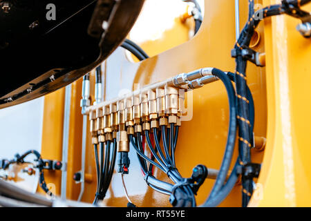Pipes and tubes of the hydraulic system of a modern excavator tractor - engineering of powerful details of the work machine  Stock Photo