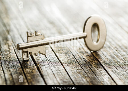 One safe key on old wooden table. Stock Photo