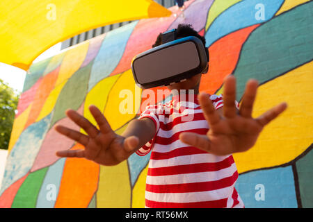 Schoolboy using virtual reality headset in the school playground Stock Photo