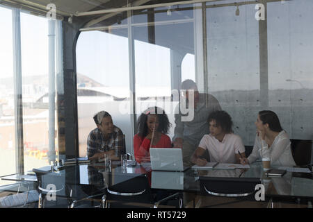 Business colleagues discussing over laptop in office Stock Photo