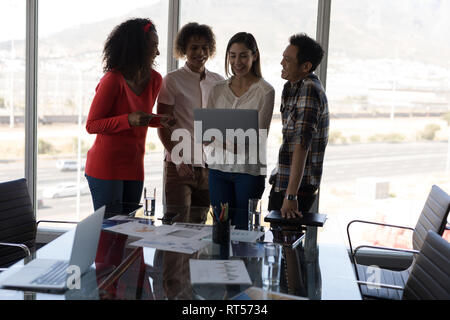 Business colleagues discussing over laptop Stock Photo