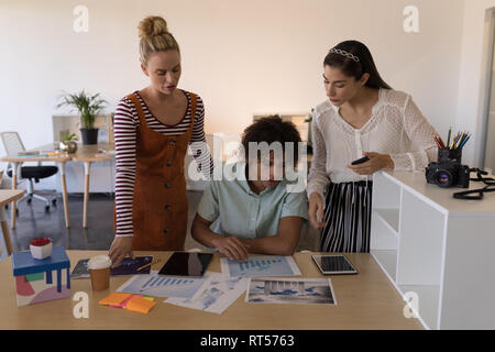 Business colleagues discussing over graph in office Stock Photo