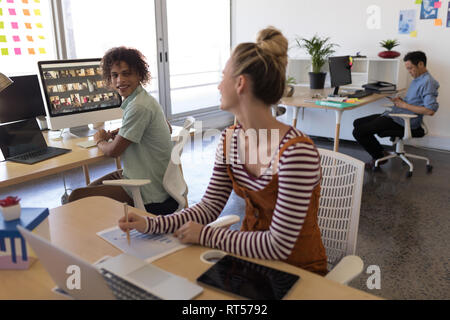 Business colleagues interacting with each other at desk Stock Photo