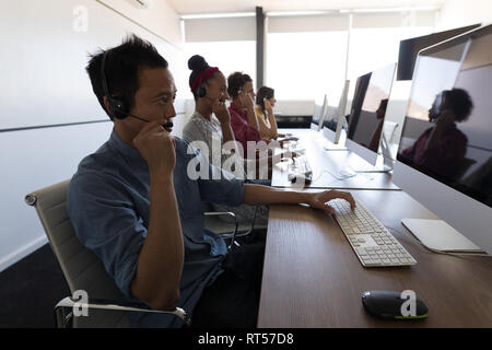 Executives talking on headset in office Stock Photo