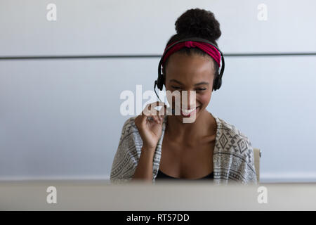 Female executive talking on headset in office Stock Photo