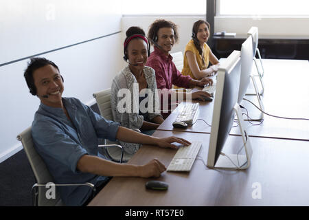 Executives talking on headset in office Stock Photo