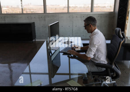 Male executive working on computer at desk Stock Photo