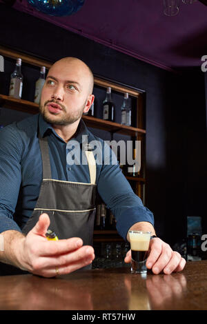 The bartender prepares a B-52 cocktail at the bar. Stock Photo