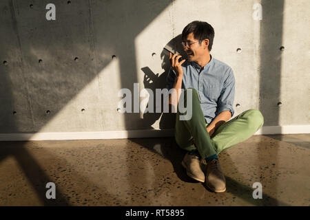 Male executive talking on mobile phone in office Stock Photo
