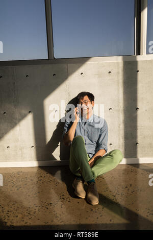 Male executive talking on mobile phone in office Stock Photo