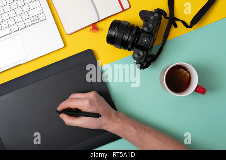 Designer using graphic tablet in digital work and photo editing. Top flat lay view Stock Photo