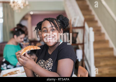 Portrait confident tween girl eating pizza Stock Photo