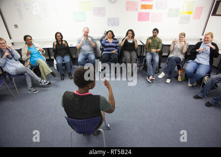 adults in a further education college learning how to use sign language Stock Photo