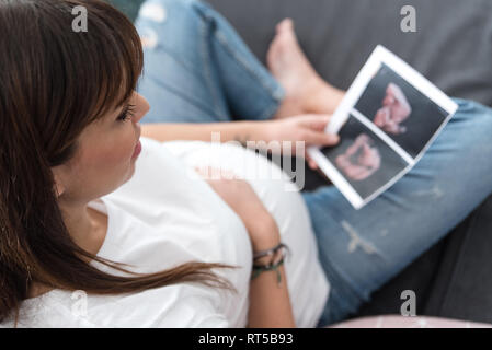 Pregnant woman holds ultrasound photo Stock Photo