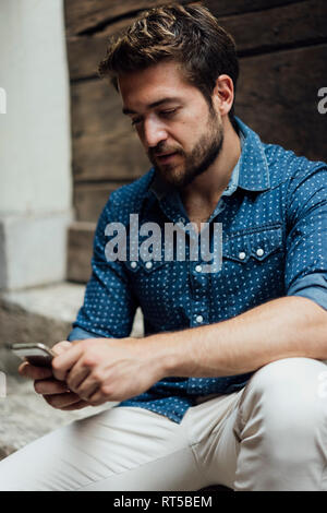 Businessman text messaging outdoors Stock Photo