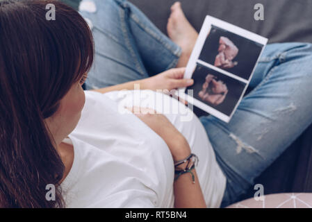 Pregnant woman holds ultrasound photo Stock Photo