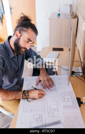 Young architect working at home with blueprints Stock Photo
