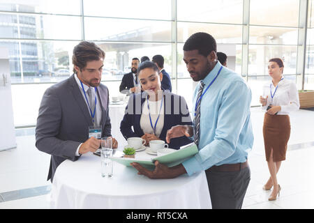 Business people discussing over documents at table during a seminar Stock Photo