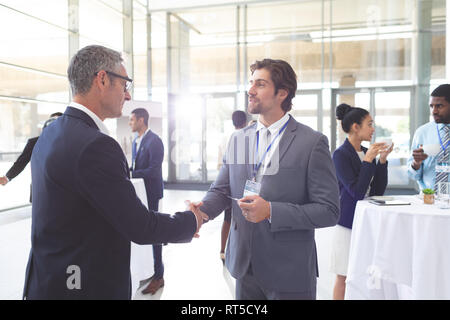 Business people shaking hand during a seminar Stock Photo