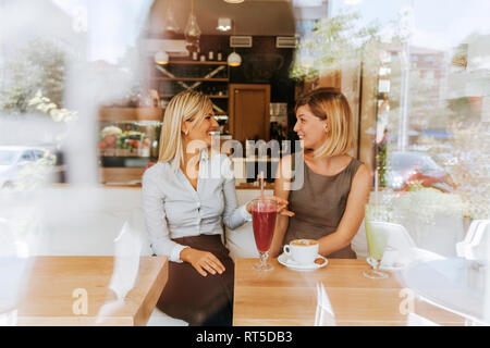 Two happy young women in a cafe Stock Photo