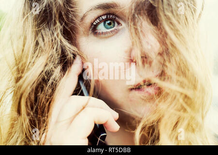Portrait of young woman on the phone, close-up Stock Photo
