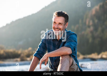 Mature man camping at riverside Stock Photo