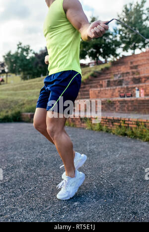 Close-up of muscular man skipping rope outdoors Stock Photo