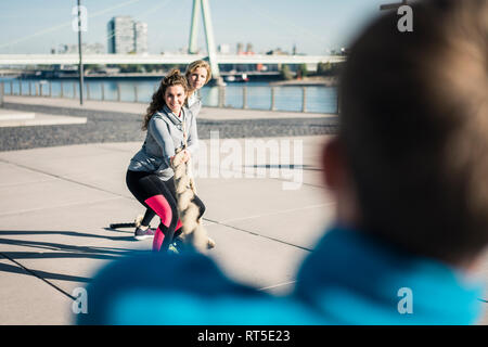 Friends training at the riverside, pulling rope Stock Photo