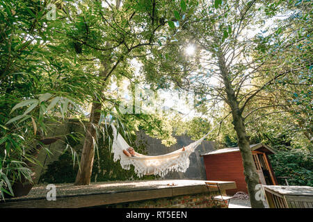 Woman relaxing in hammock in the garden Stock Photo