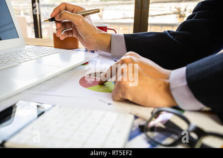 Businessman or accountant working on calculator to calculate business data concept. Accounting,investment advisor consulting situation on the financia Stock Photo