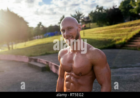 Portrait of smiling barechested muscular man outdoors Stock Photo