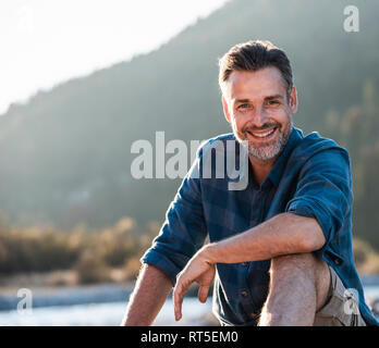 Mature man camping at riverside Stock Photo