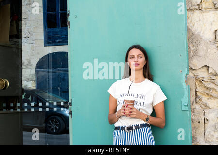 Portrait of young woman with paper cup of iced coffee Stock Photo