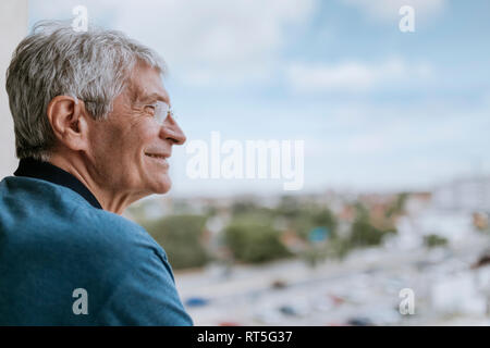 Smiling senior man with hearing aid outdoors Stock Photo