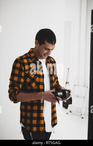 Smiling photographer looking at camera in studio Stock Photo