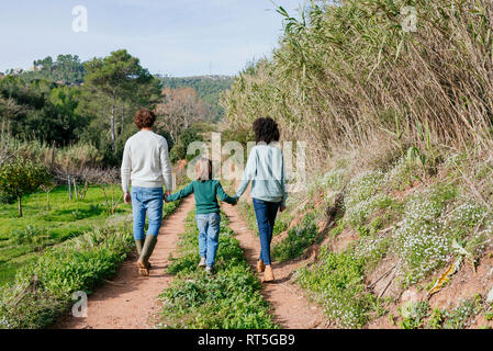 Happy family walking in the countryside, holding hands Stock Photo