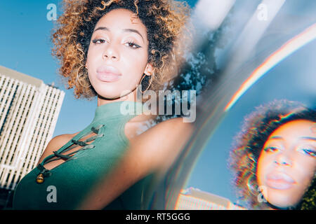 Portrait of attractive young woman with reflections in the city
