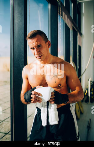 Portrait of boxer preparing to fight holding boxing glove Stock Photo