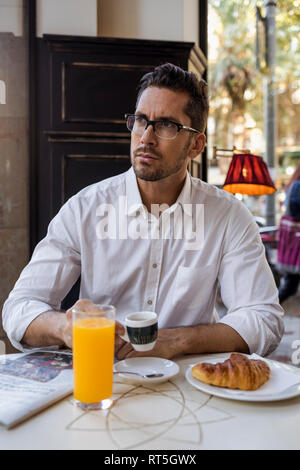 Businessman having breakfast in a cafe Stock Photo