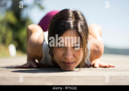 Mature woman practicing yoga in summer on a jetty Stock Photo