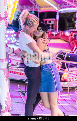 Mother and daughter hugging  at fair Stock Photo