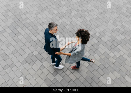 Top view of two colleagues shaking hands on a square Stock Photo