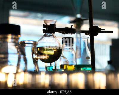 Flask containing a chemical formula being held by a retort stand in a laboratory